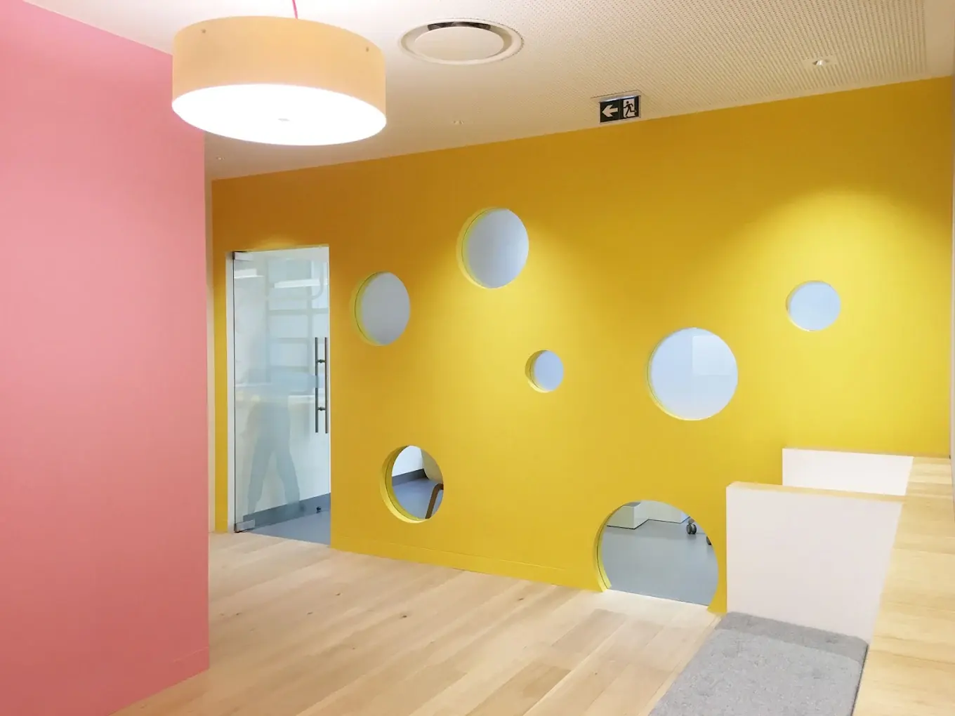 Espace d'accueil enfants du Cabinet de la Grand-Place — mur jaune et hublots colorés