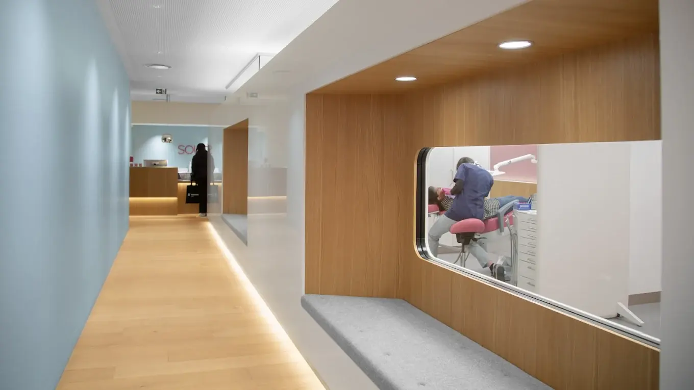 Couloir du cabinet dentaire et salle de soins vue par le hublot — Cabinet de la Grand-Place, Boulogne-Billancourt